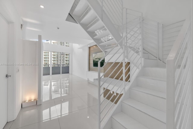 staircase featuring tile patterned flooring and recessed lighting