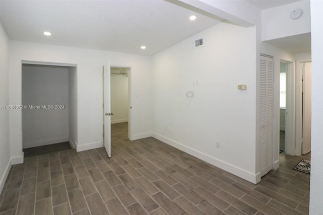 unfurnished bedroom featuring dark wood-type flooring and vaulted ceiling