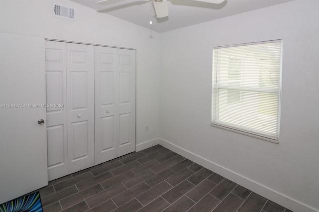 unfurnished bedroom featuring ceiling fan and a closet