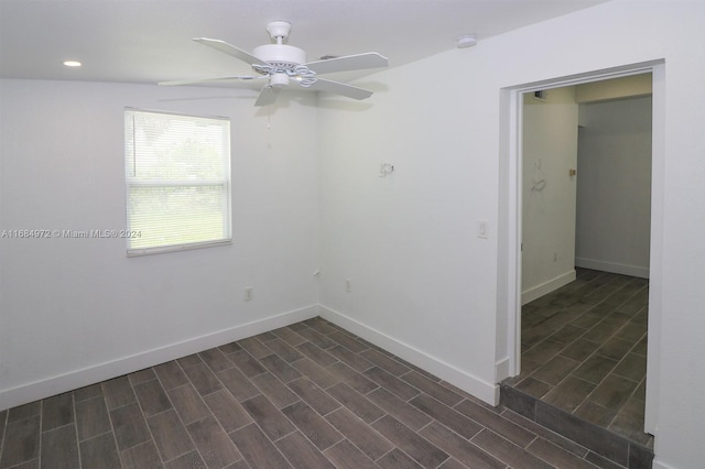 empty room with ceiling fan and dark wood-type flooring