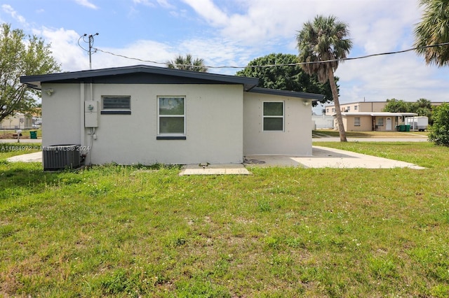 rear view of property with a yard and central AC unit