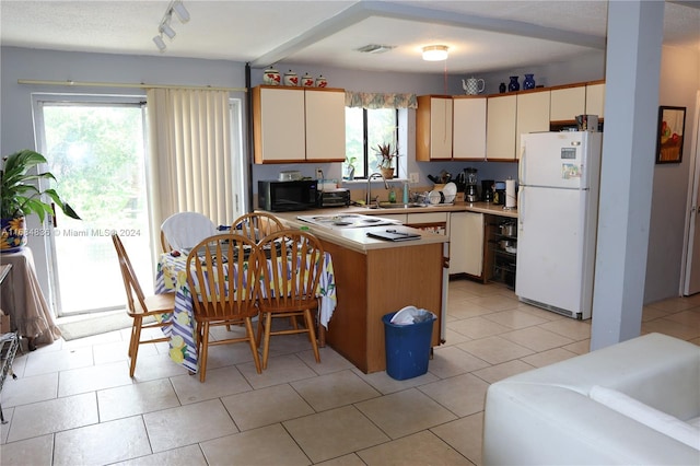 kitchen featuring cream cabinets, white appliances, and plenty of natural light