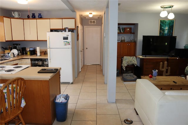 kitchen featuring a textured ceiling, decorative light fixtures, light tile patterned floors, and white appliances