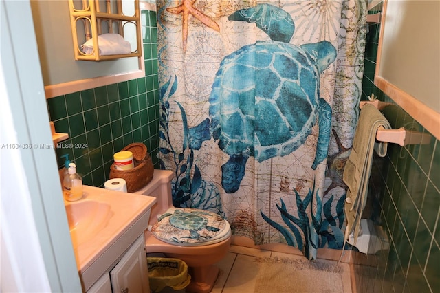 bathroom featuring tile walls, toilet, vanity, a shower with curtain, and tile patterned floors