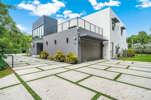 6695 SW 112th St, Pinecrest, FL 33156 - view of side of property with a balcony, a garage, driveway, and stucco siding