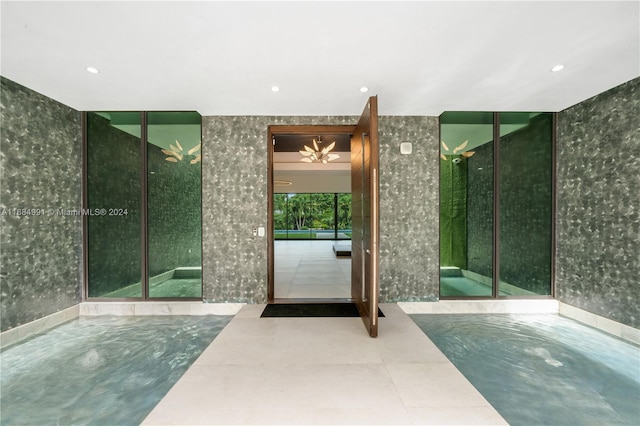 bathroom featuring tile patterned flooring, a wall of windows, and a chandelier