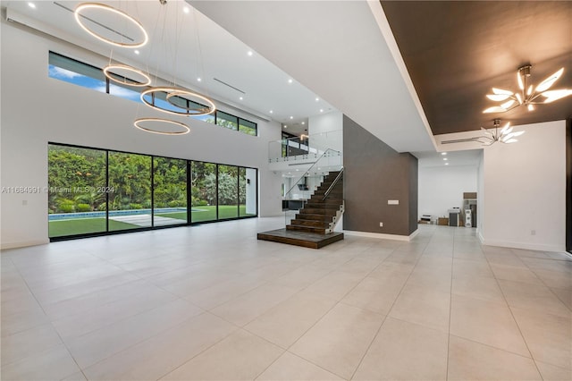 unfurnished living room with light tile patterned floors, a high ceiling, and a notable chandelier