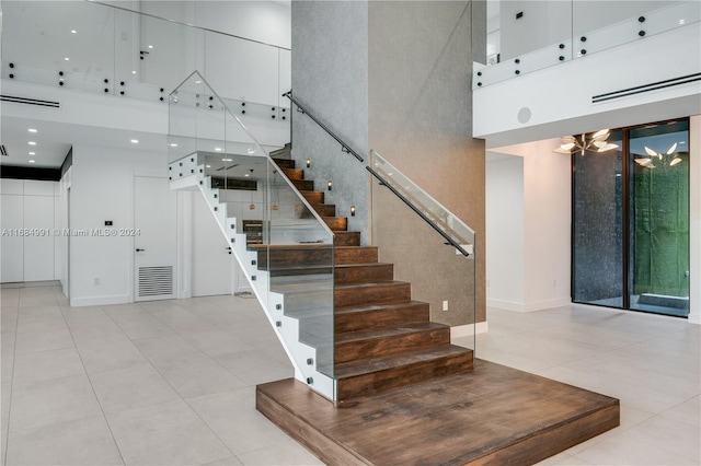 staircase featuring tile patterned floors and a high ceiling