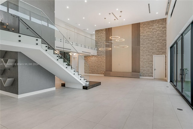 staircase with tile patterned flooring and a towering ceiling