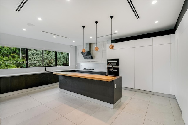 6695 SW 112th St, Pinecrest, FL 33156 - kitchen featuring wood counters, wall chimney exhaust hood, a sink, modern cabinets, and white cabinets