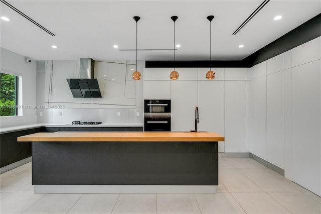 6695 SW 112th St, Pinecrest, FL 33156 - kitchen with multiple ovens, ventilation hood, a kitchen island, decorative light fixtures, and white cabinetry