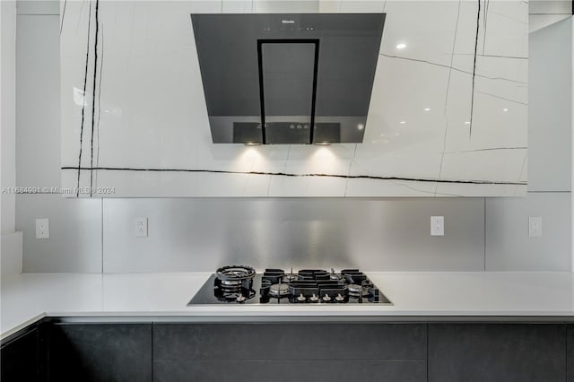 room details featuring range hood and black gas cooktop