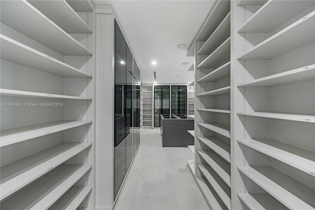 walk in closet with light tile patterned flooring