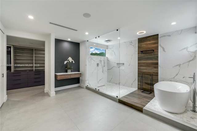 6695 SW 112th St, Pinecrest, FL 33156 - bathroom featuring tile walls, recessed lighting, a marble finish shower, a freestanding bath, and a spacious closet