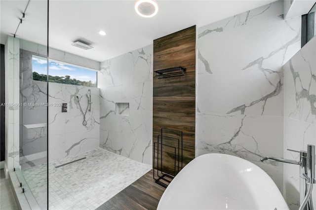 bathroom with hardwood / wood-style floors, tile walls, and shower with separate bathtub