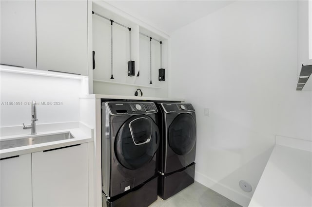 laundry area with cabinets, independent washer and dryer, and sink