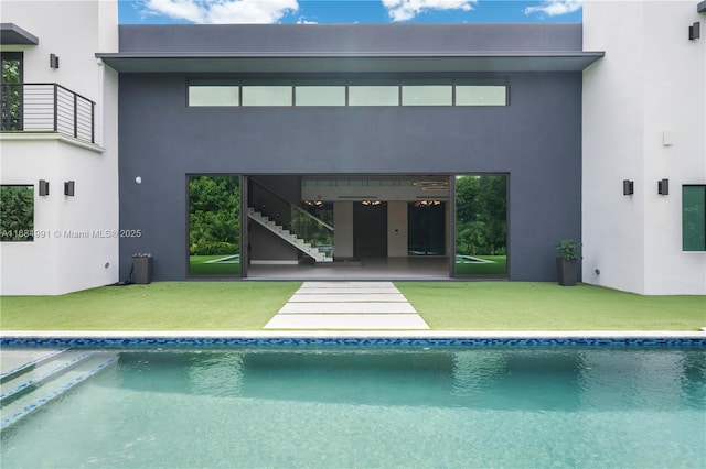 6695 SW 112th St, Pinecrest, FL 33156 - back of house featuring stairs, an outdoor pool, a lawn, and stucco siding