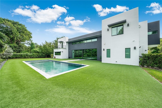 6695 SW 112th St, Pinecrest, FL 33156 - back of property with a lawn, an outdoor pool, and stucco siding