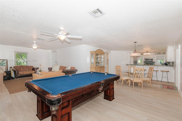 game room featuring light hardwood / wood-style floors, a textured ceiling, pool table, and ceiling fan