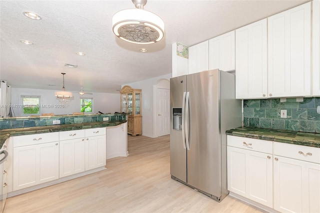 kitchen featuring stainless steel fridge with ice dispenser, white cabinets, and backsplash