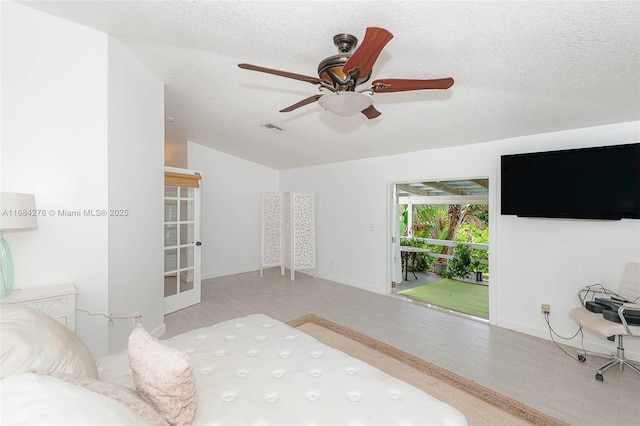 bedroom featuring ceiling fan, access to exterior, a textured ceiling, and lofted ceiling