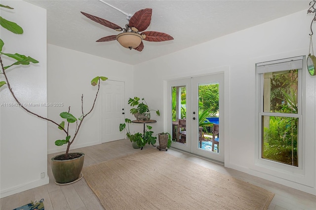 living area with ceiling fan, light wood-type flooring, and french doors