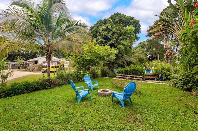 surrounding community featuring an outdoor fire pit and a lawn