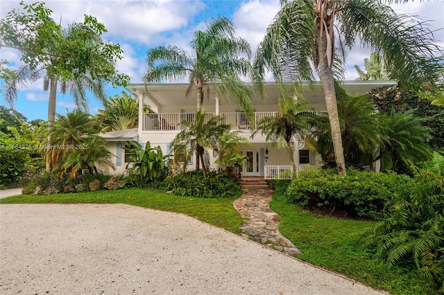 mediterranean / spanish-style house with french doors, a balcony, and a front yard