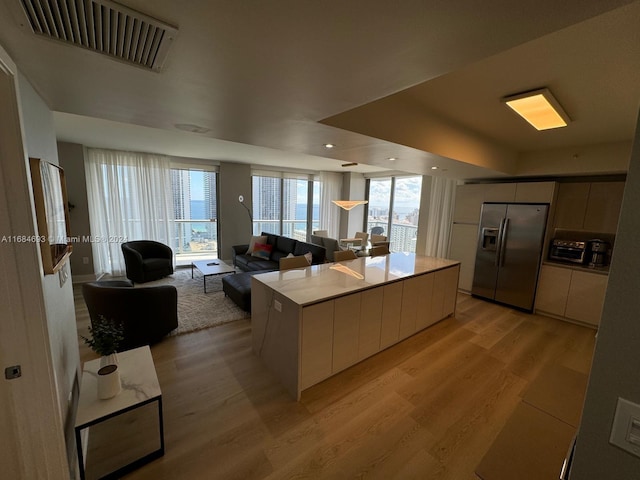 kitchen featuring light hardwood / wood-style floors, a kitchen island, and stainless steel fridge