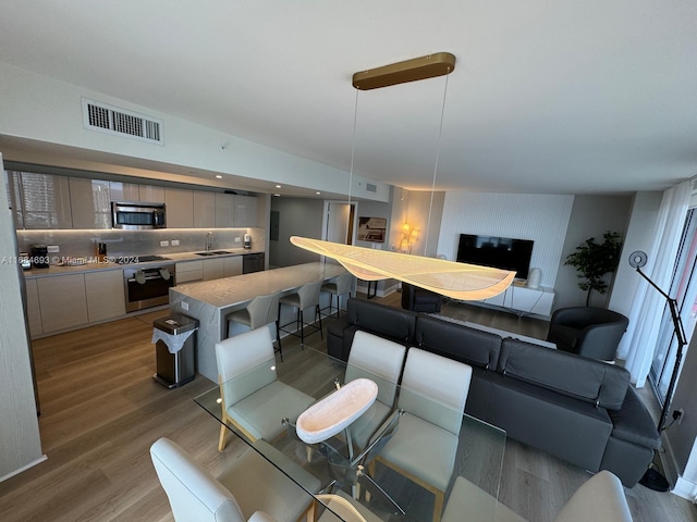 dining space featuring hardwood / wood-style flooring, sink, and a wealth of natural light