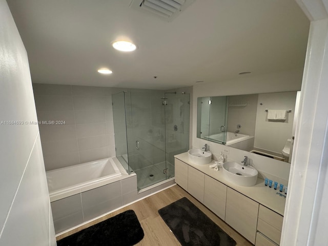 bathroom with vanity, independent shower and bath, and hardwood / wood-style flooring