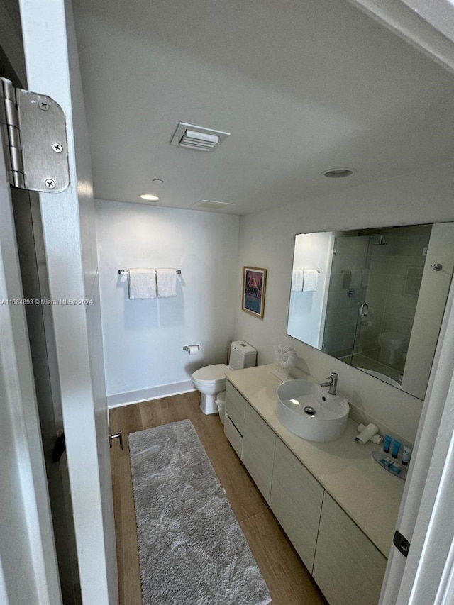 bathroom with vanity, toilet, an enclosed shower, and hardwood / wood-style floors