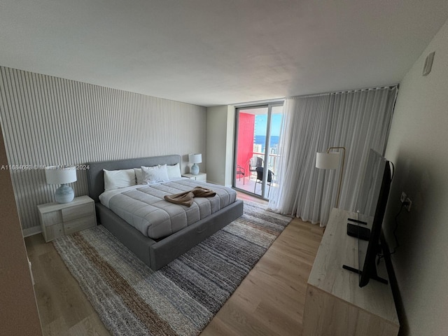 bedroom featuring access to exterior and wood-type flooring