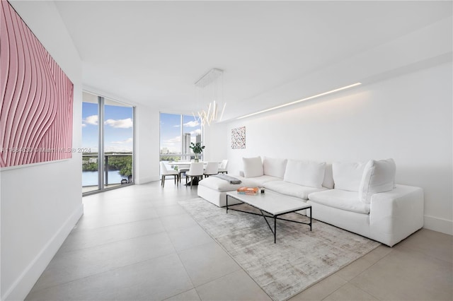 living room featuring a chandelier, a water view, and a wall of windows