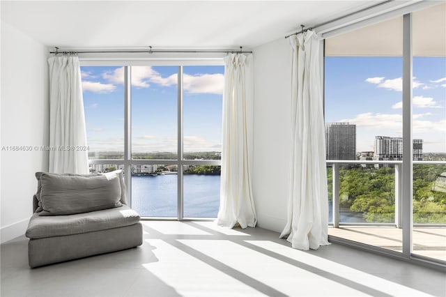 unfurnished room with a water view and expansive windows