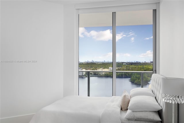 bedroom with a water view and multiple windows