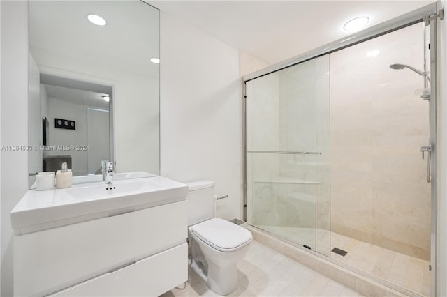 bathroom with vanity, toilet, and a shower with shower door