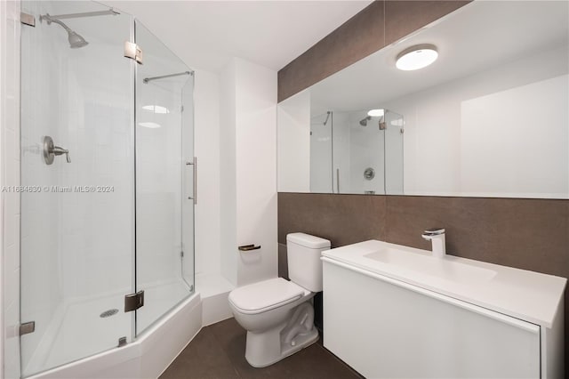 bathroom featuring vanity, an enclosed shower, and toilet