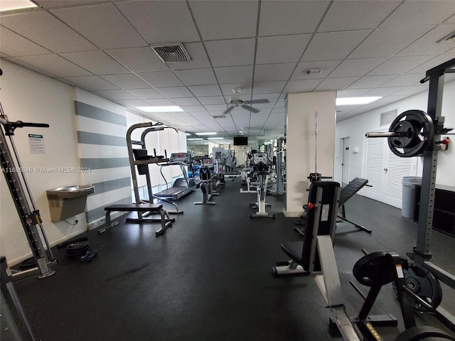 workout area featuring a paneled ceiling and ceiling fan