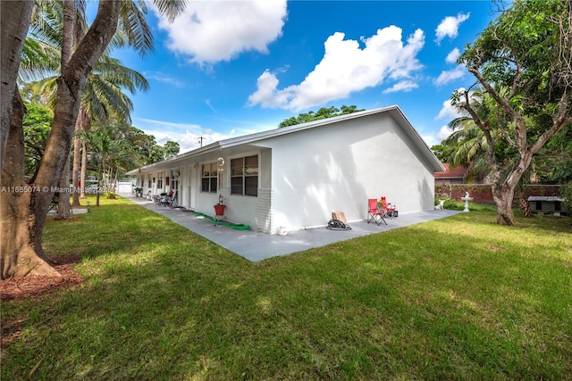 back of property with a patio and a yard