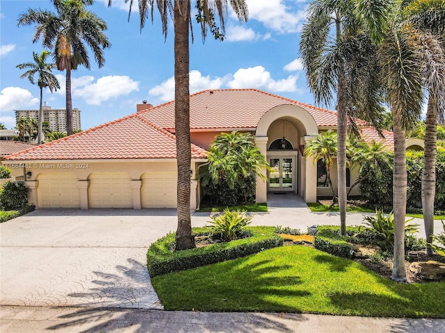 34 Pelican Dr, Fort Lauderdale, FL 33301 - mediterranean / spanish-style house featuring french doors, a garage, concrete driveway, stucco siding, and a tiled roof