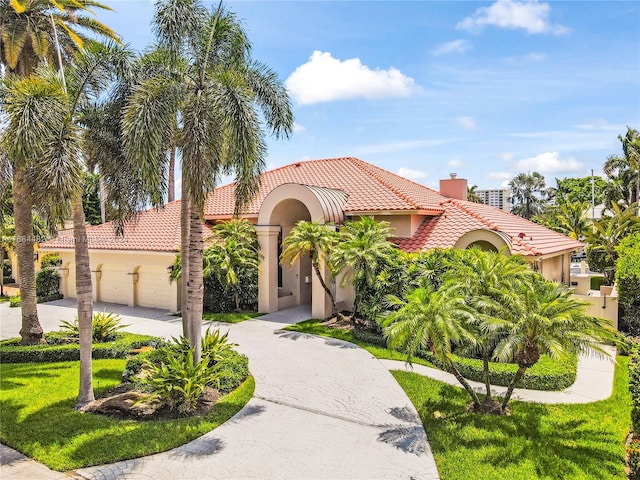 mediterranean / spanish house with a front yard and a garage