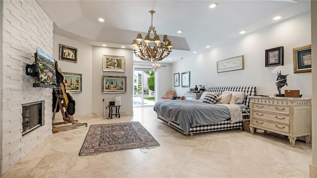 bedroom featuring a stone fireplace, access to exterior, and a chandelier