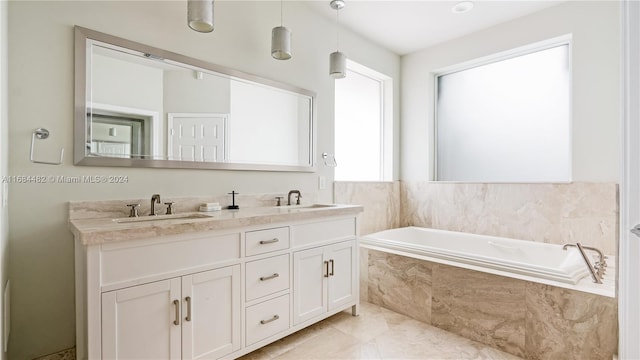 bathroom featuring vanity, tile patterned flooring, and tiled tub