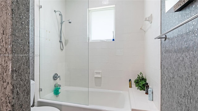 bathroom with toilet and tiled shower / bath