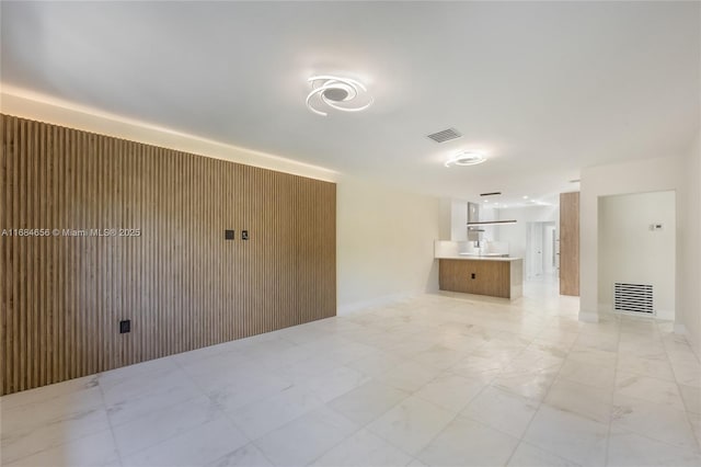 unfurnished living room with visible vents and a sink