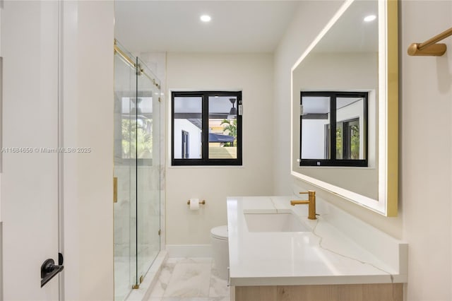 bathroom featuring toilet, marble finish floor, a stall shower, and vanity