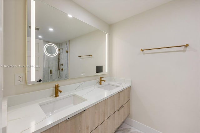 full bath with double vanity, marble finish floor, a shower stall, and a sink