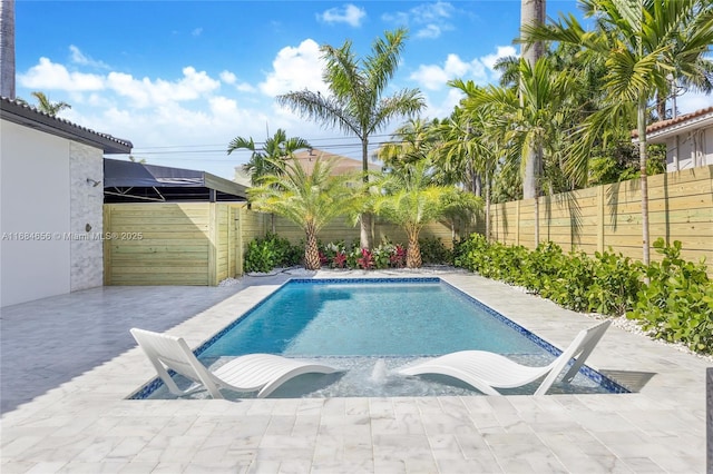 view of swimming pool with a fenced in pool, a fenced backyard, and a patio