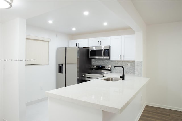 kitchen featuring backsplash, white cabinetry, dark wood-type flooring, sink, and stainless steel appliances